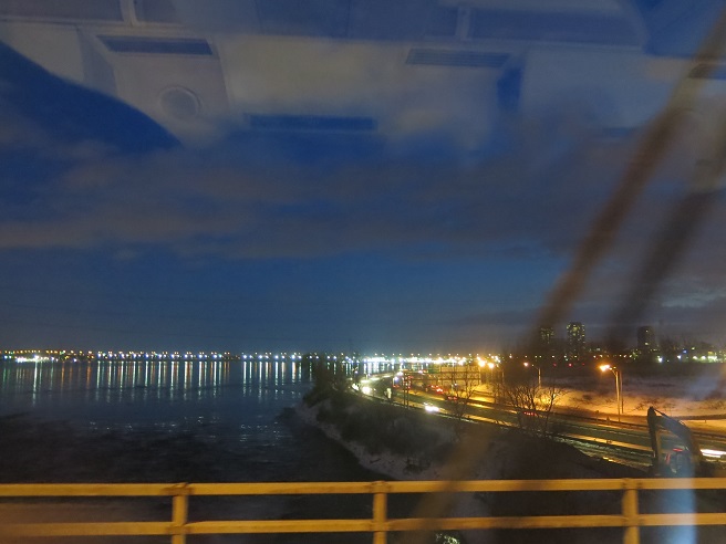 An impressionistic photo of Montreal at dusk, taken from the train bridge